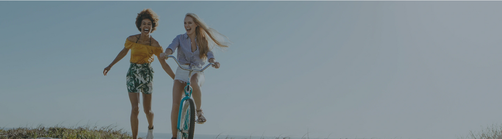 One woman riding a bicycle and another woman running next to her.