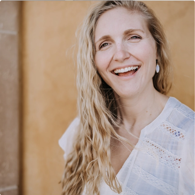 A woman with blonde hair smiling at the camera.