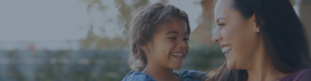 A mother and daughter smiling at each other.