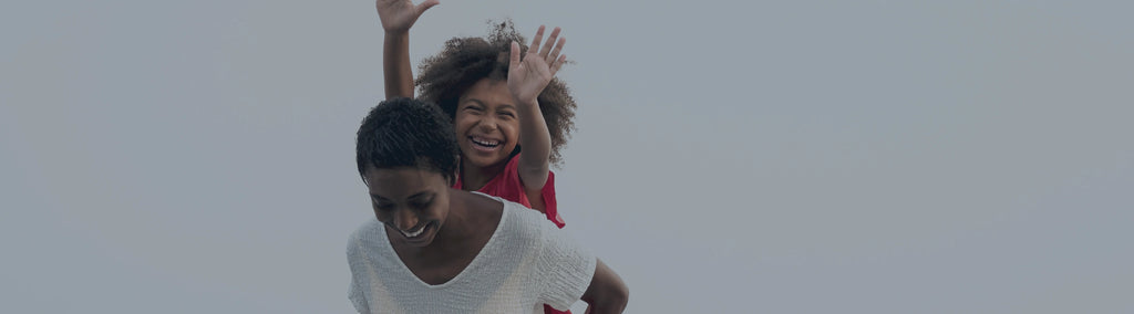 A mother giving a piggyback ride to a young child.